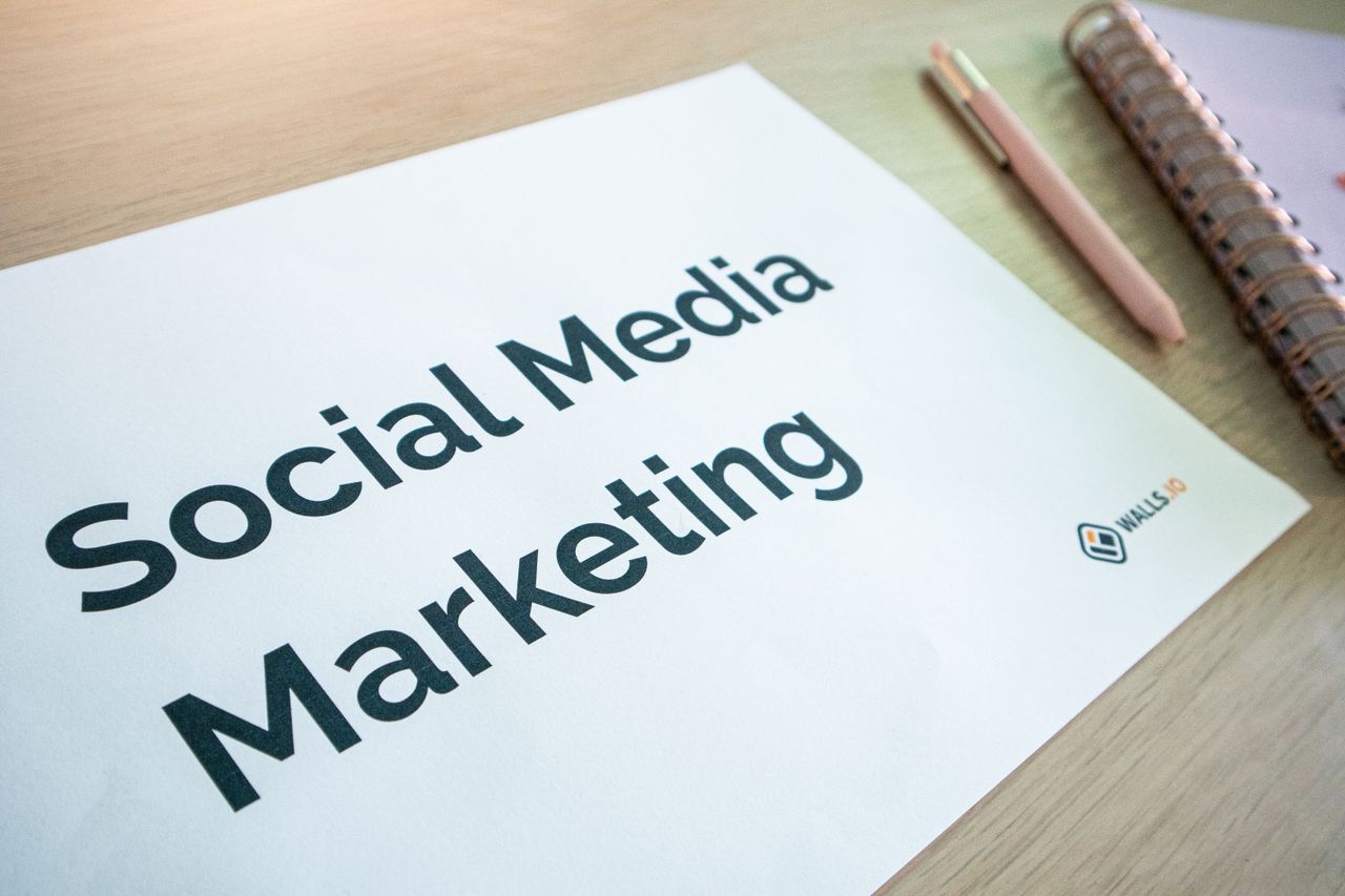 Vue rapprochée d’un document de marketing sur les réseaux sociaux posé sur un bureau avec un stylo et un carnet.
